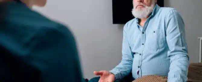 senior man sitting on doctor table talking